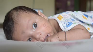 关闭脸可爱的新生儿婴儿男孩说谎床上月甜蜜的婴儿蹒跚学步的特写镜头肖像印度种族孩子健康护理发展背景